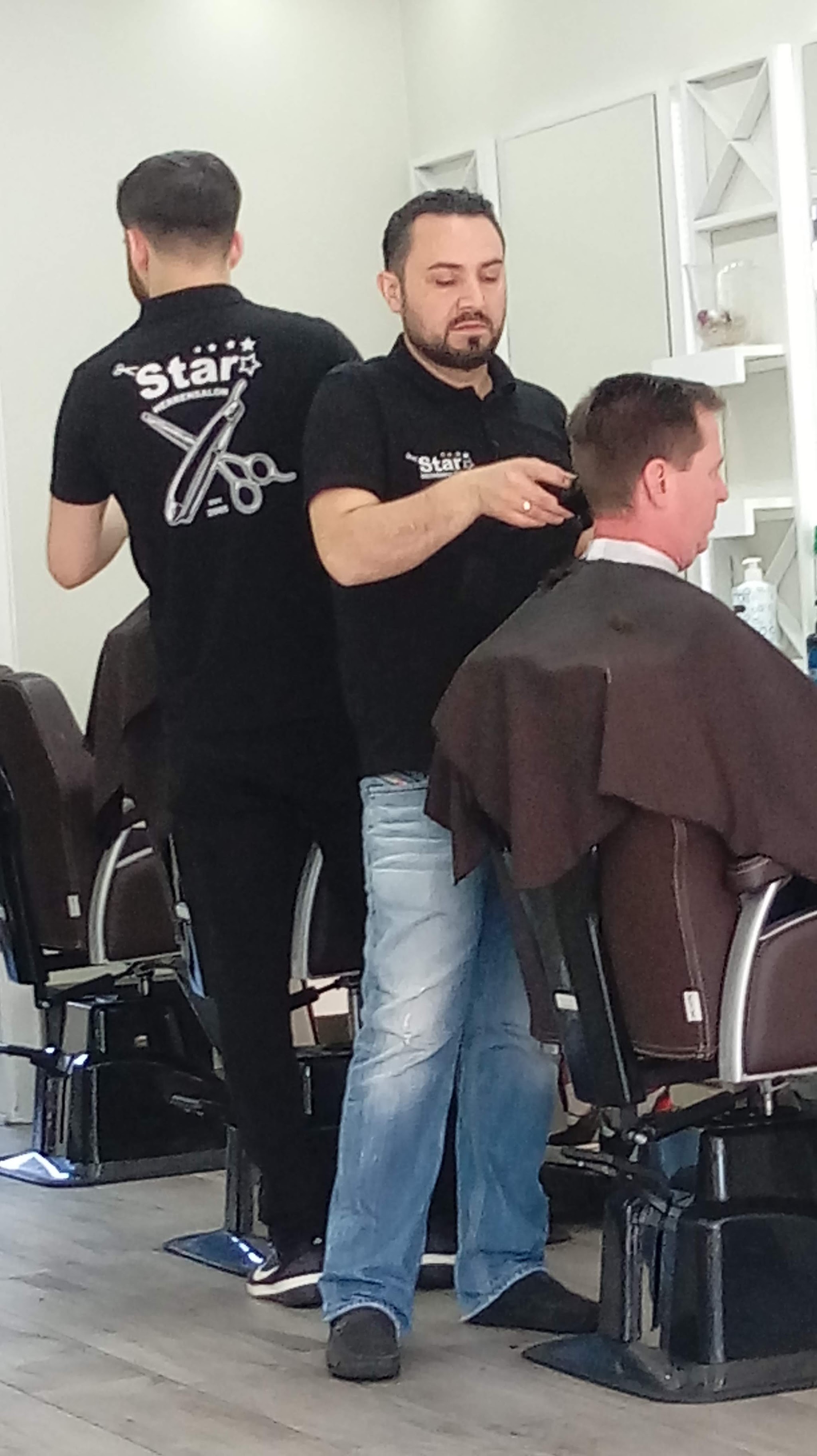 Zwei Barbiere von Star Herren Salon bei der Arbeit